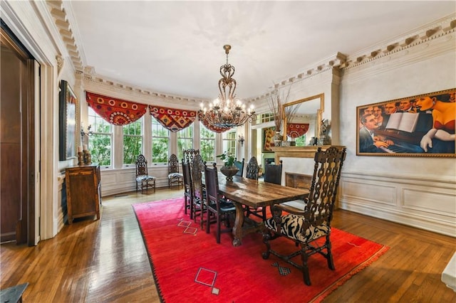 dining space with crown molding, wood-type flooring, and a notable chandelier