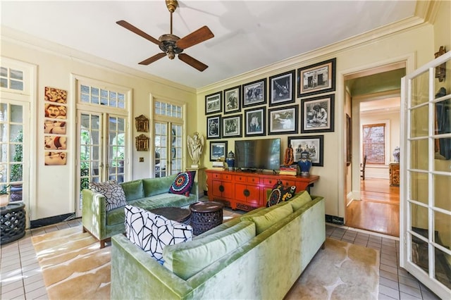 living room with french doors, ceiling fan, crown molding, and light tile patterned floors