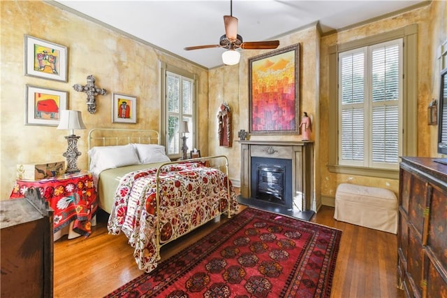 bedroom featuring ceiling fan, ornamental molding, and dark hardwood / wood-style flooring