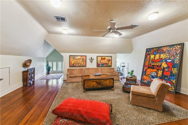 living room with vaulted ceiling, a textured ceiling, ceiling fan, and dark hardwood / wood-style flooring