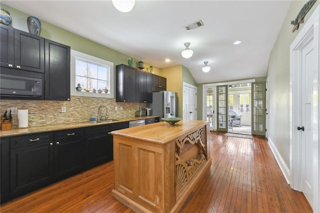 kitchen featuring decorative backsplash, stainless steel appliances, french doors, and a healthy amount of sunlight