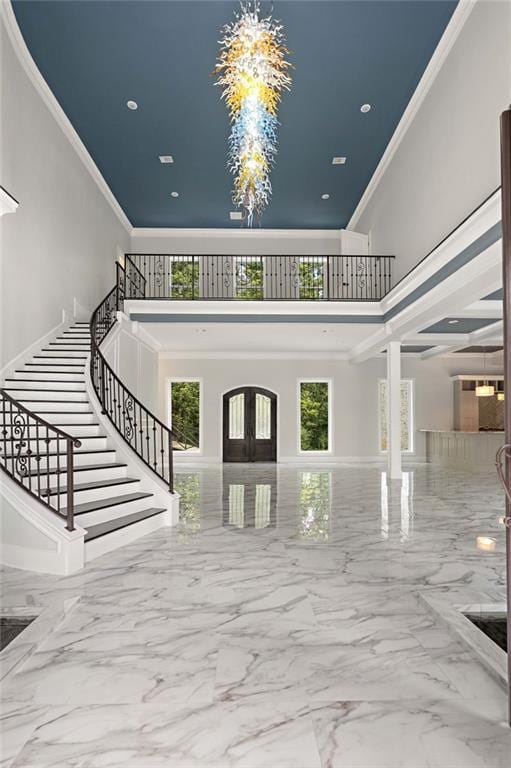 entryway featuring ornamental molding, a wealth of natural light, and a high ceiling