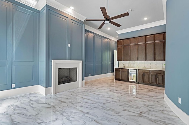 kitchen featuring wine cooler, crown molding, dark brown cabinetry, and ceiling fan