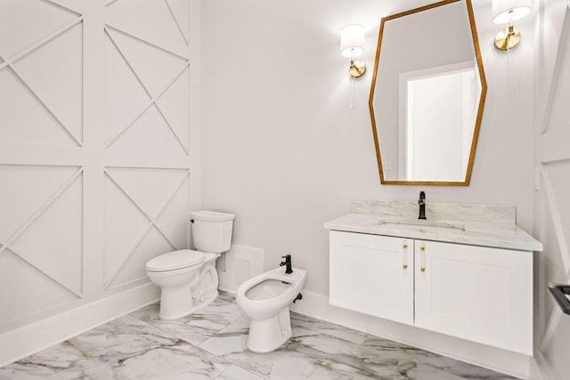 bathroom with a bidet, vanity, and toilet