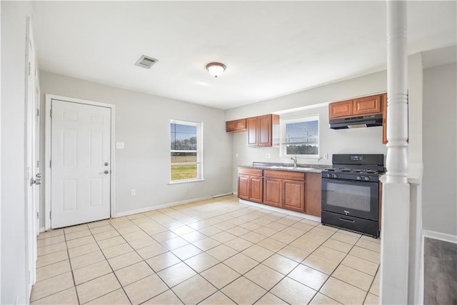 kitchen featuring black range with gas cooktop, sink, and light tile patterned floors