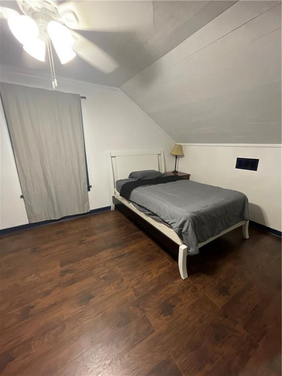 bedroom featuring lofted ceiling, dark wood-type flooring, and ceiling fan