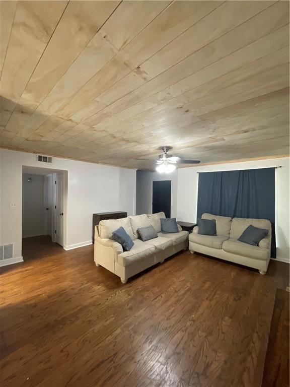 living room featuring dark hardwood / wood-style flooring, wooden ceiling, and ceiling fan