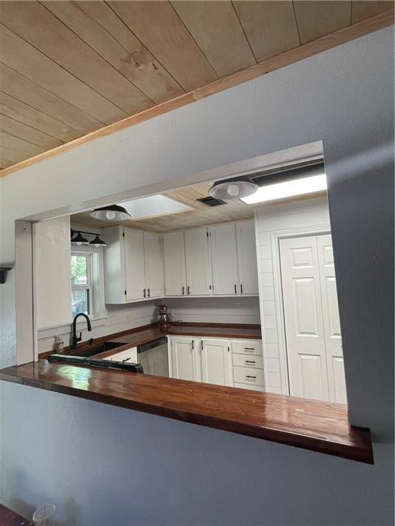 kitchen featuring sink, wood ceiling, stainless steel dishwasher, and white cabinets