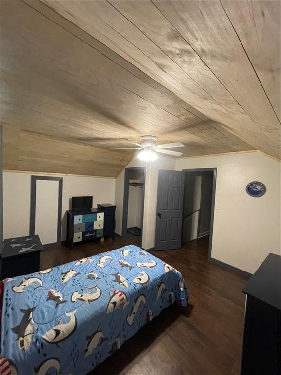 bedroom featuring dark hardwood / wood-style flooring, vaulted ceiling, wooden ceiling, and ceiling fan