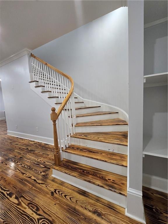 stairway with crown molding and hardwood / wood-style floors