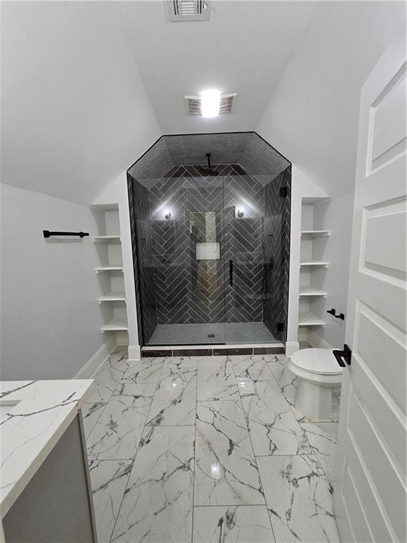 bathroom featuring a tile shower, vanity, vaulted ceiling, and toilet