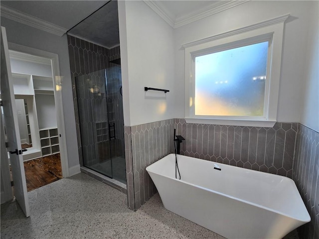 bathroom with ornamental molding, shower with separate bathtub, and tile walls