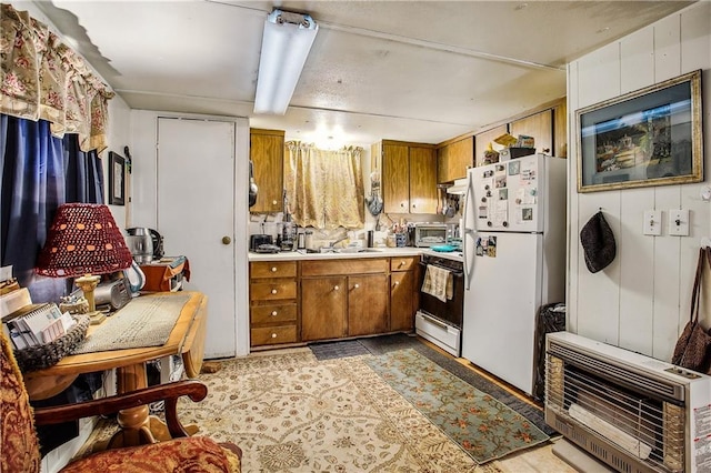 kitchen featuring heating unit, sink, and white appliances