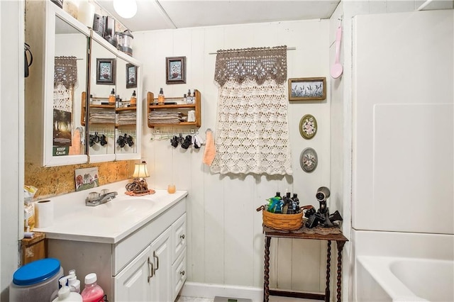 bathroom with vanity and a washtub