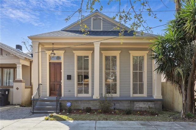 view of front of house featuring roof with shingles and fence