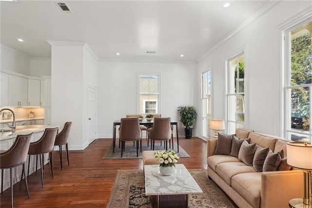 living room featuring visible vents, baseboards, dark wood-type flooring, and ornamental molding