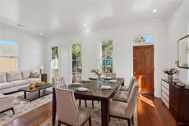 dining room with dark wood-type flooring, crown molding, visible vents, and a healthy amount of sunlight