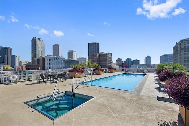 view of swimming pool with a hot tub and a patio area