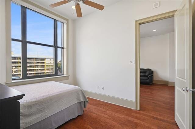 bedroom with dark hardwood / wood-style flooring and ceiling fan