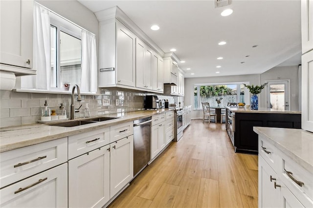 kitchen featuring white cabinetry, appliances with stainless steel finishes, sink, and light hardwood / wood-style floors