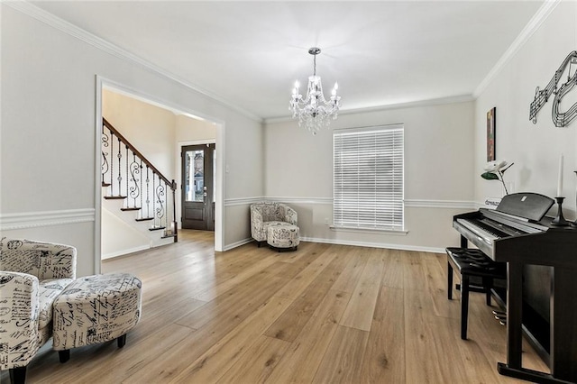 sitting room with ornamental molding, a chandelier, and light wood-type flooring