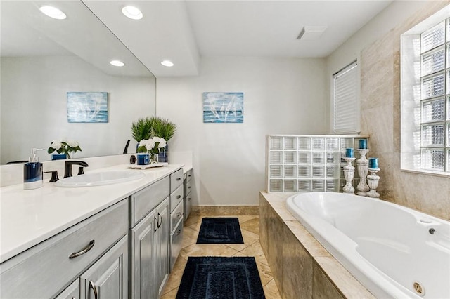 bathroom with vanity, a relaxing tiled tub, and tile patterned floors