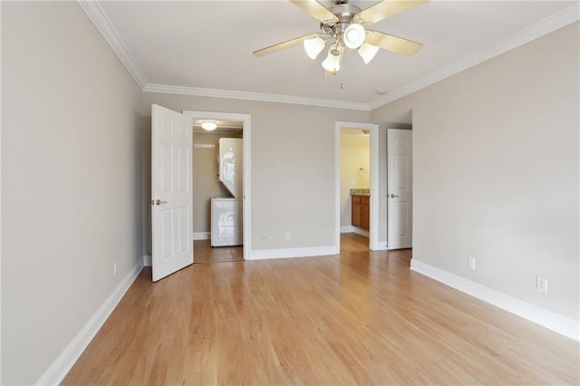 unfurnished bedroom featuring ornamental molding, stacked washer / drying machine, ensuite bath, and light hardwood / wood-style flooring