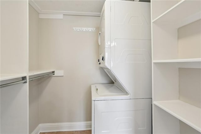 clothes washing area featuring stacked washer and clothes dryer