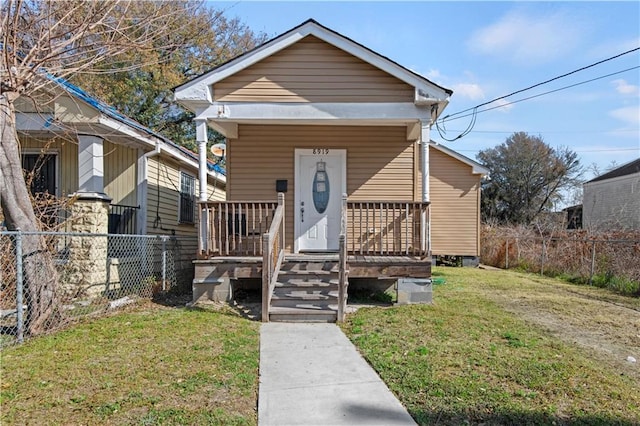 bungalow-style house featuring covered porch and a front lawn