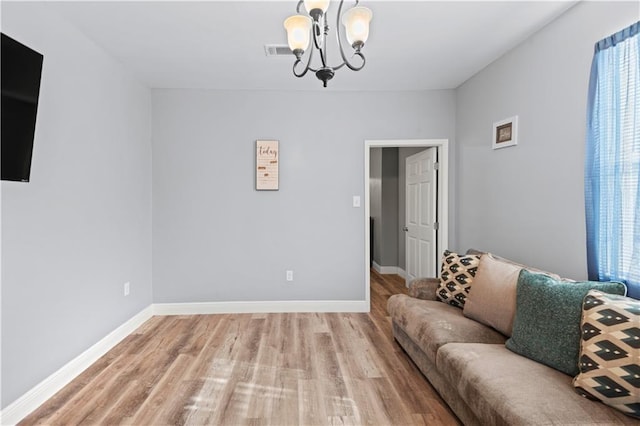 living room featuring light hardwood / wood-style floors and a notable chandelier