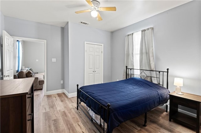 bedroom featuring ceiling fan, light wood-type flooring, and a closet