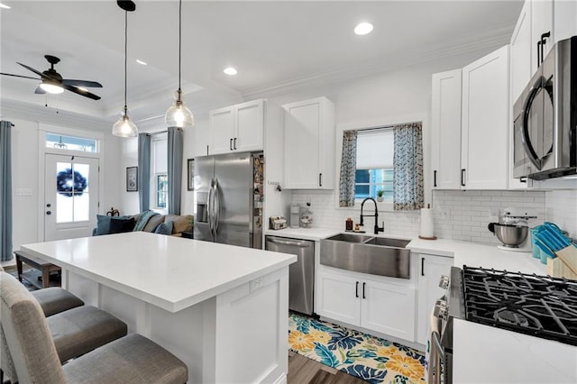 kitchen with sink, stainless steel appliances, a kitchen breakfast bar, and white cabinets