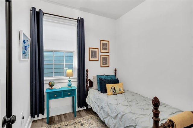 bedroom with baseboards and wood finished floors