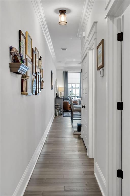 hall with hardwood / wood-style floors and ornamental molding