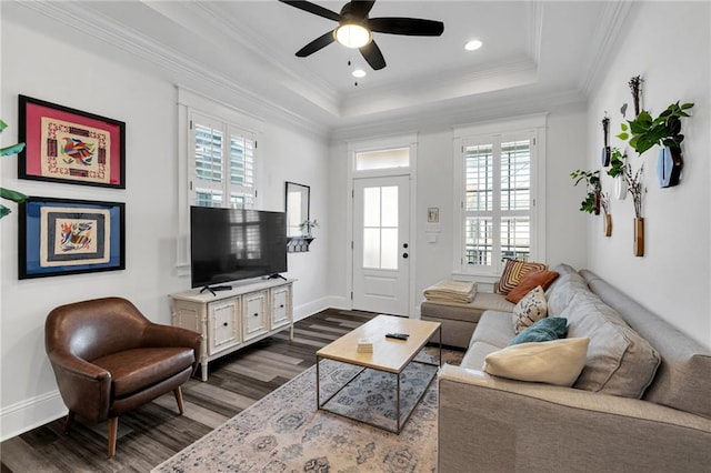 living room featuring hardwood / wood-style flooring, ornamental molding, a tray ceiling, and a wealth of natural light