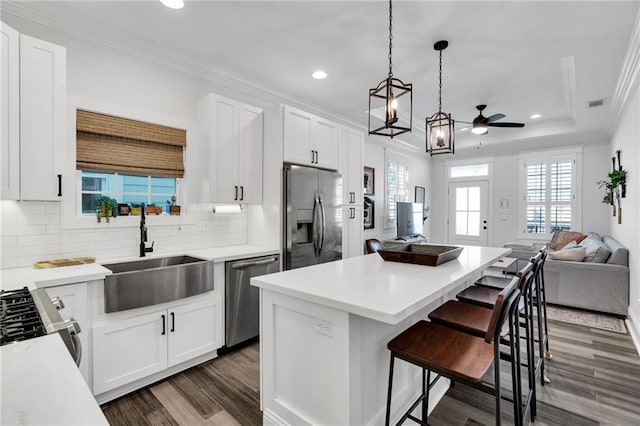 kitchen with white cabinetry, sink, decorative light fixtures, and stainless steel appliances