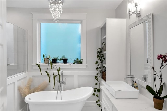 bathroom with an inviting chandelier, sink, and a bathtub