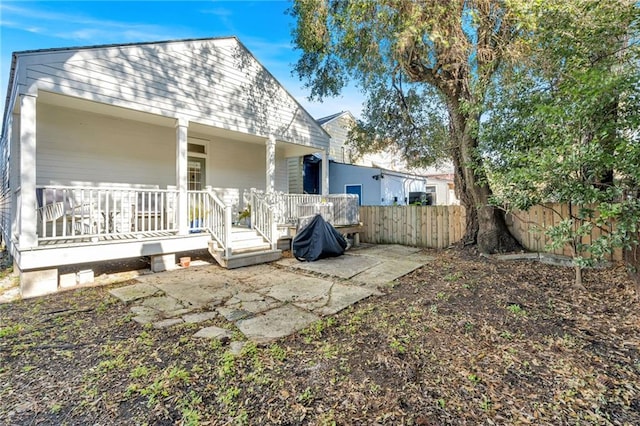 back of house with covered porch and a patio area