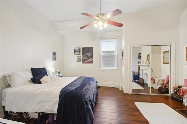 bedroom with dark wood-style floors, ceiling fan, and baseboards