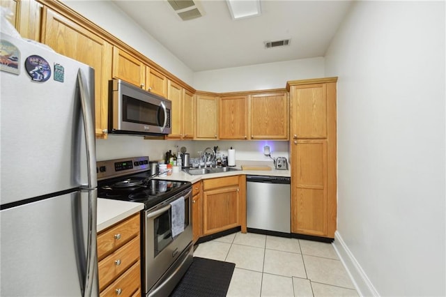 kitchen featuring visible vents, stainless steel appliances, a sink, and light tile patterned flooring