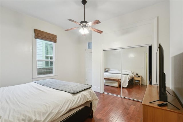 bedroom featuring a closet, wood-type flooring, and a ceiling fan