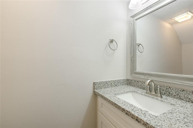 bathroom featuring vanity and lofted ceiling