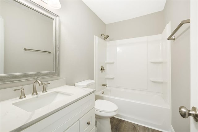 full bathroom featuring hardwood / wood-style flooring, bathing tub / shower combination, vanity, and toilet