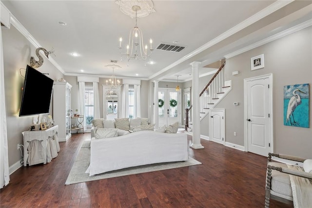 living room with crown molding, dark hardwood / wood-style floors, french doors, a chandelier, and ornate columns