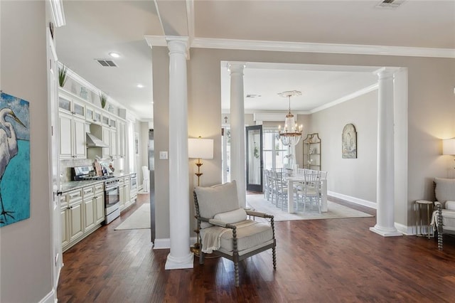 interior space with white cabinetry, stainless steel range with gas cooktop, and ornate columns