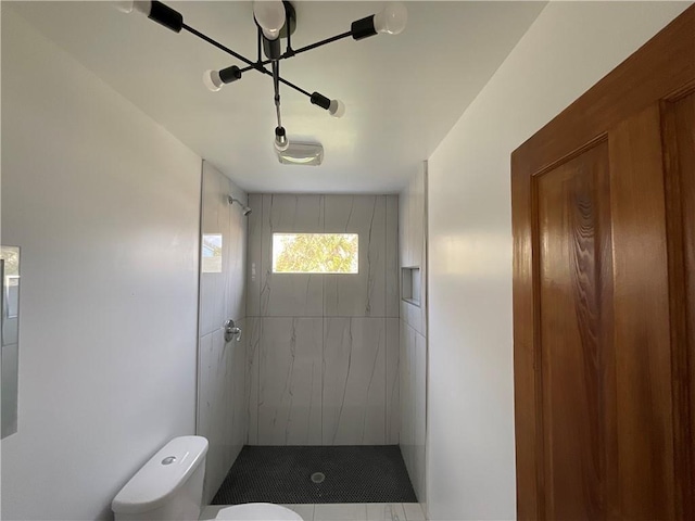 bathroom with tiled shower and toilet