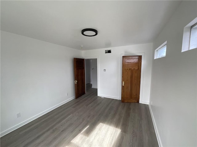 empty room with dark hardwood / wood-style flooring