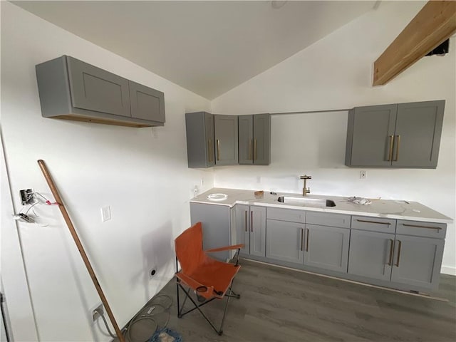 kitchen featuring gray cabinetry, sink, dark wood-type flooring, and lofted ceiling