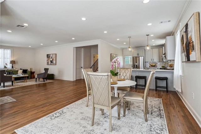 dining room featuring hardwood / wood-style floors, crown molding, and a wealth of natural light