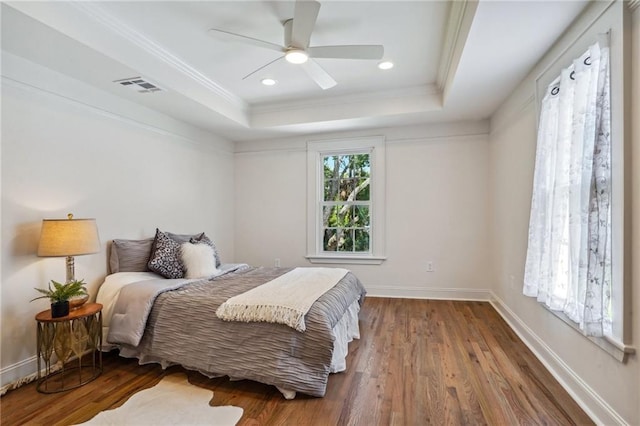 bedroom featuring hardwood / wood-style floors, crown molding, a raised ceiling, and ceiling fan